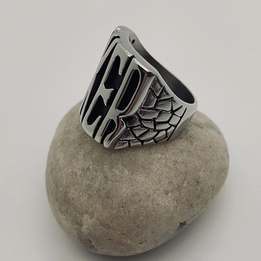 flip off middle finger ring stainless steel statement piece bold and enduring rebellious spirit rugged durability edgy style bikers motorcycle riders rock punk goth fashion big chunky ring eye-catching design substantial jewelry provocative touch unisex appeal versatile jewelry collection withstands test of time resilient and striking individuality strength leather jacket rock band t-shirt goth-inspired attire unique style concert open road everyday statement accessory handcrafted